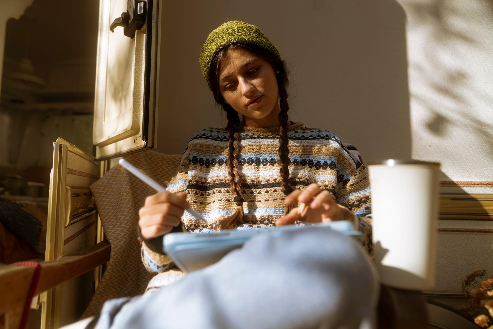 A charming girl flaunts her boho-chic style against the serene park setting, with a trailer in view.