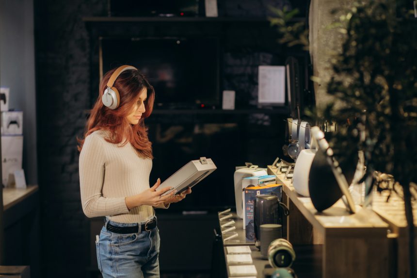 Buyer trying on headphones in audio store.