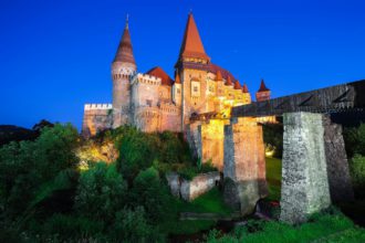 Beautiful night panorama of the Hunyad Castle / Corvin's Castle with wooden bridge.