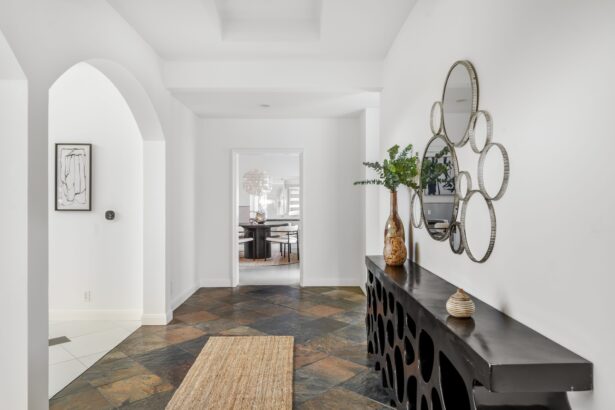 Modern hallway with decorative mirror and console table, leading to a stylish dining room